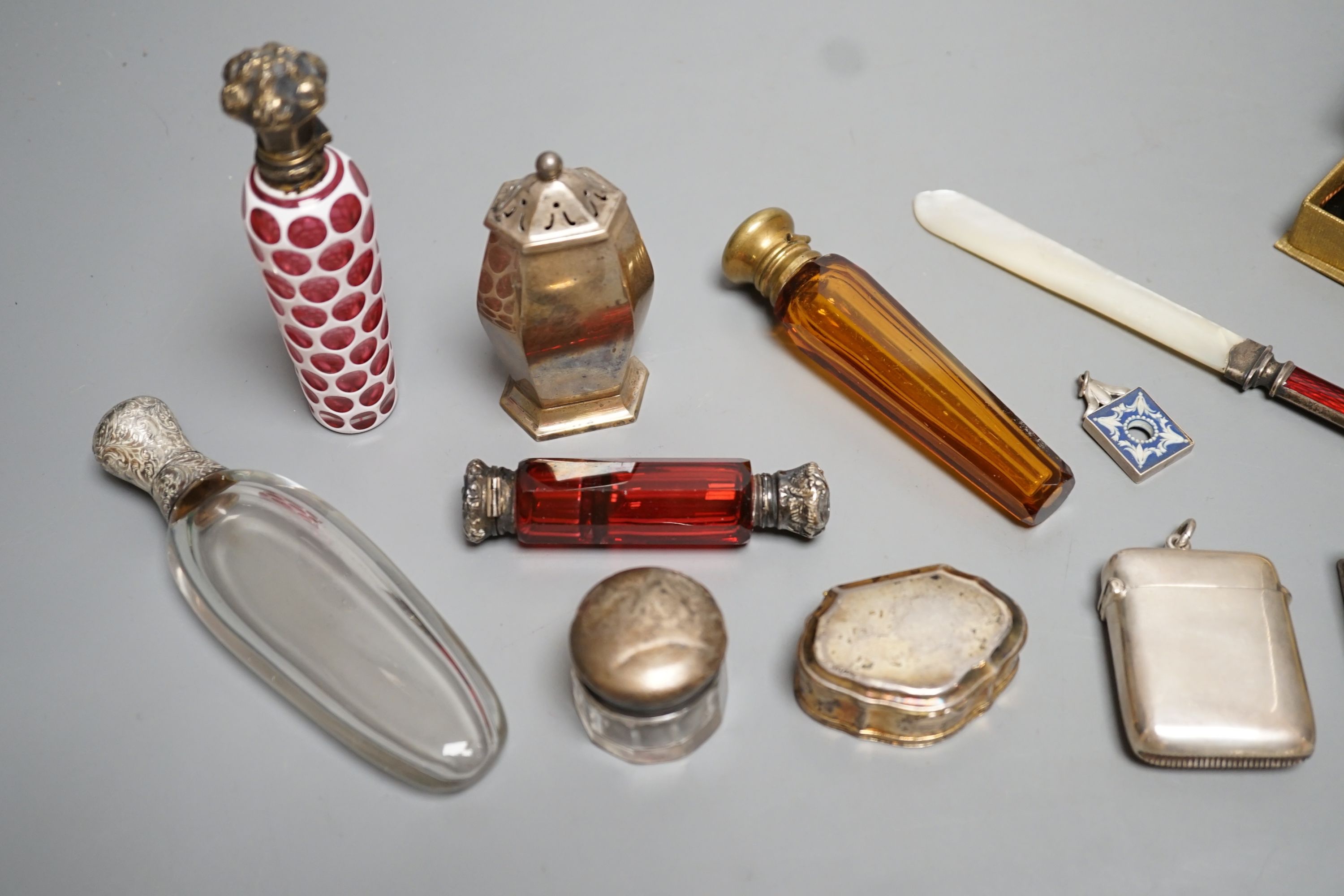 Four assorted white of gilt metal mounted glass scent bottles, largest 12.2cm, an unusual gilt white metal snuff box?, with spoon, a sterling and enamel mounted mother of pearl paper knife and other minor items.